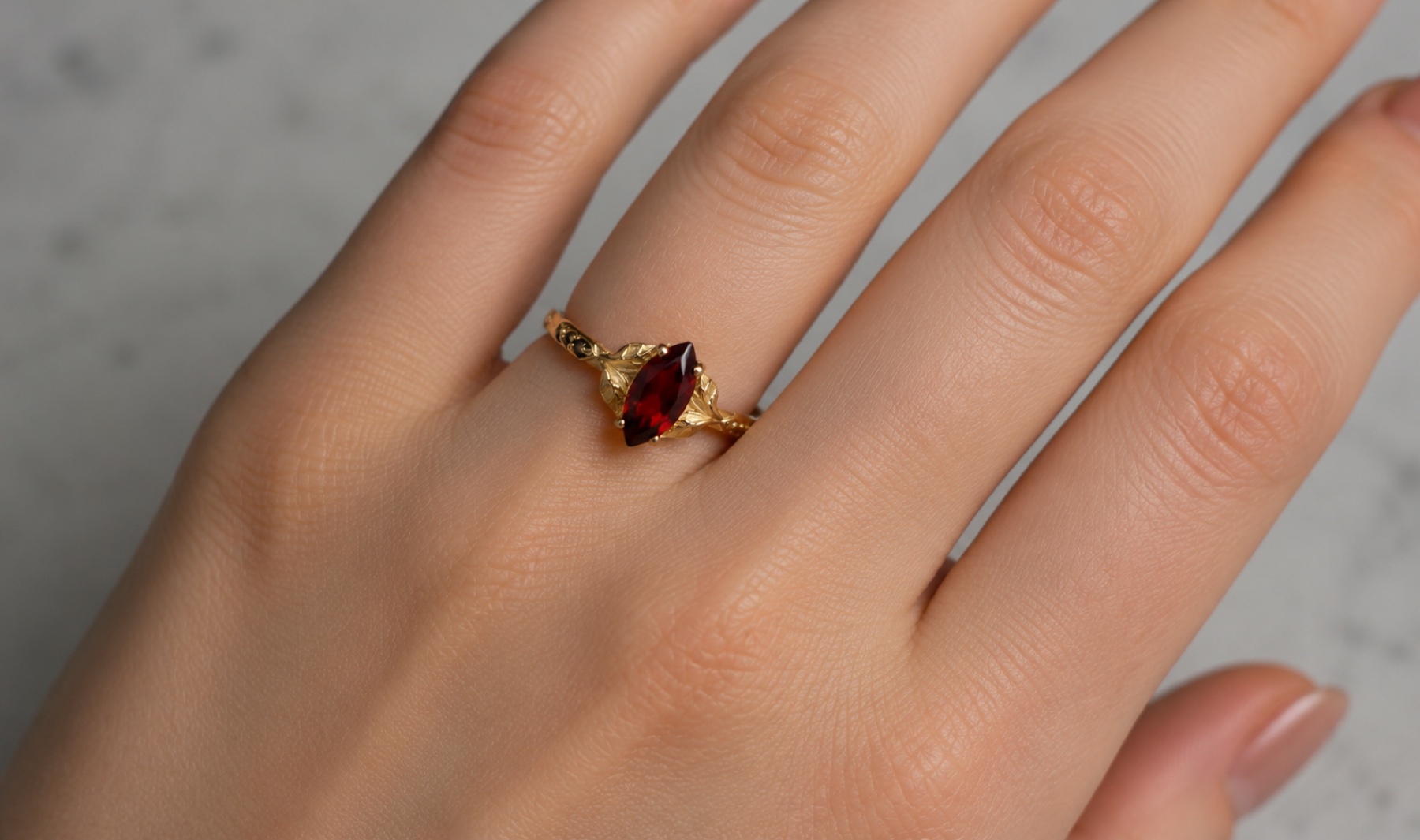Colette marquise garnet and gold leaf ring worn on a hand