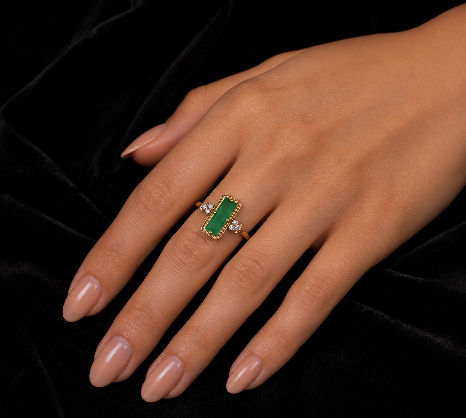 Émeraude rectangular green gemstone and gold ring worn on a hand