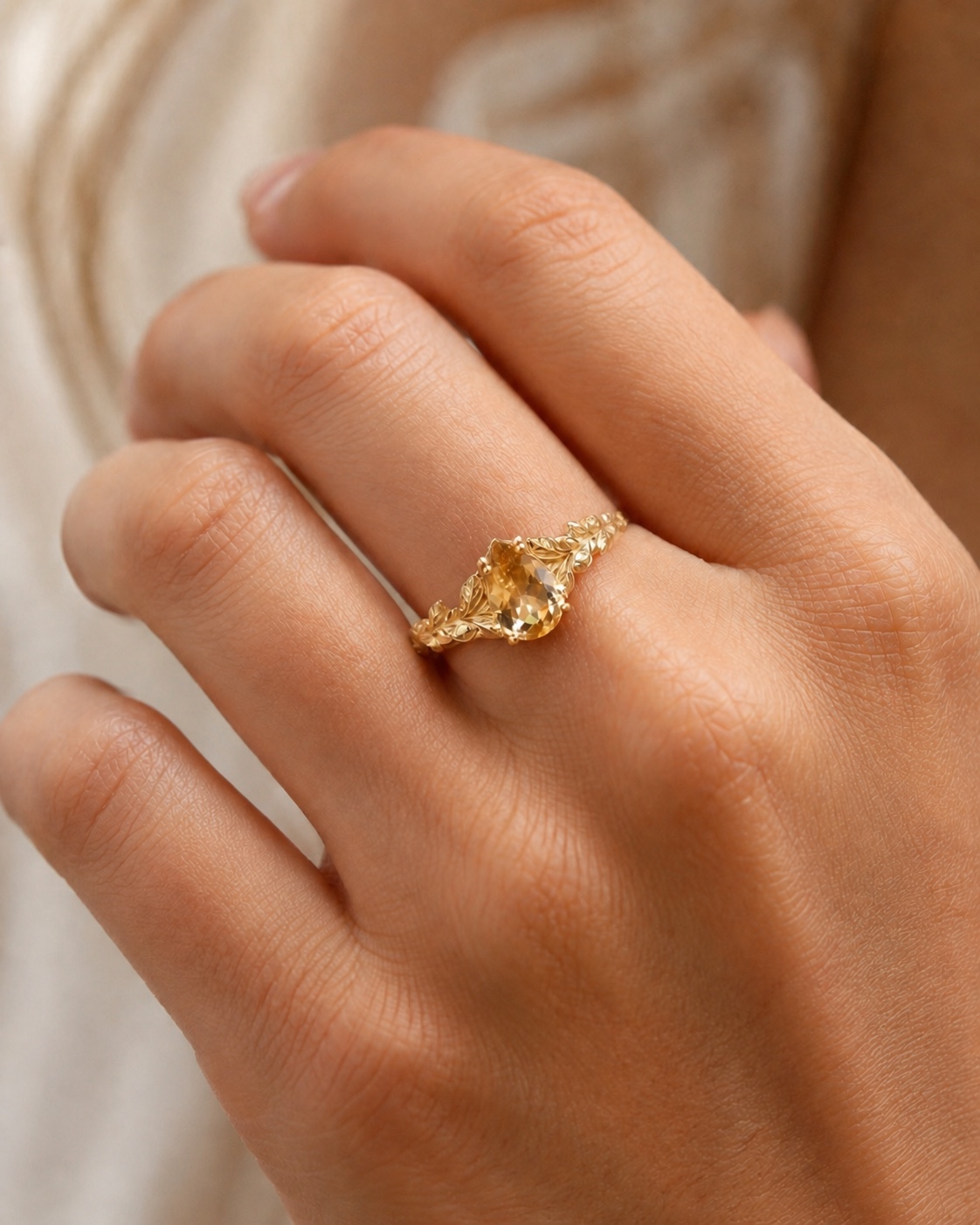 Close-up of the Solène pear-cut citrine leaf ring worn on a hand